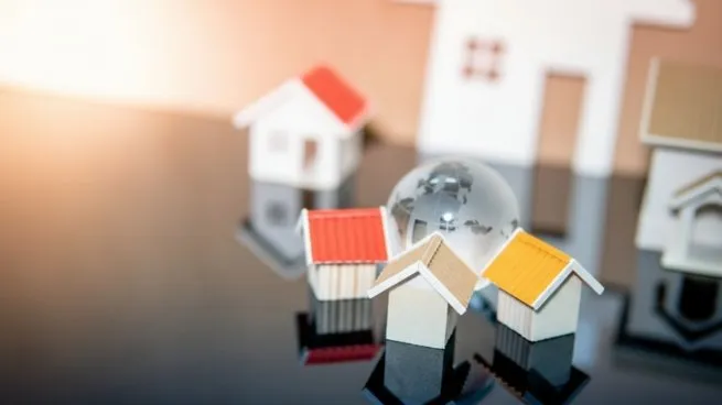 Casas en miniatura y una esfera de cristal simbolizan el mercado inmobiliario argentino 2025 y las oportunidades de inversión.